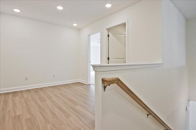 unfurnished room featuring recessed lighting, light wood-type flooring, and baseboards