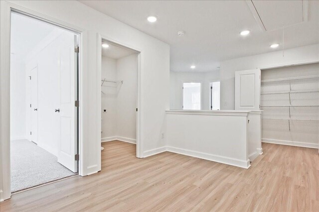 spare room featuring recessed lighting, baseboards, attic access, and light wood-style flooring