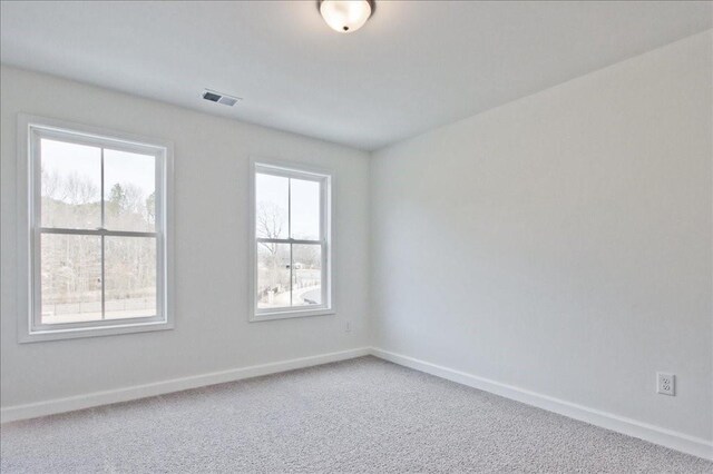 carpeted empty room with baseboards and visible vents