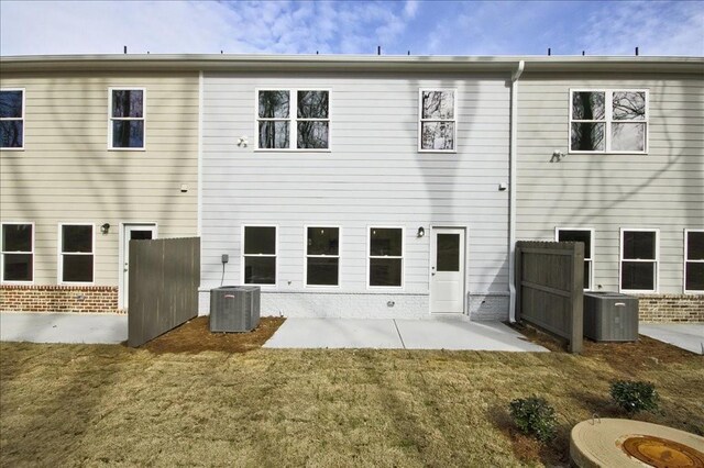 back of house featuring central air condition unit, a lawn, and a patio area