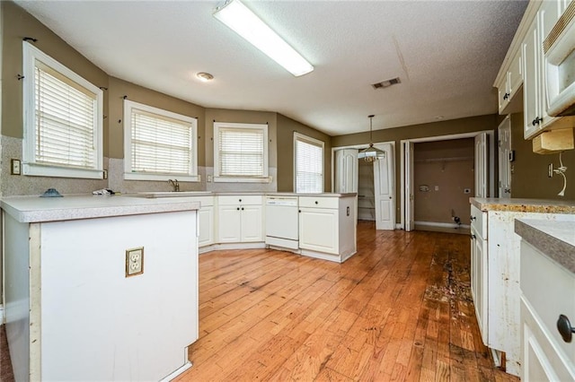 kitchen with sink, pendant lighting, white appliances, hardwood / wood-style floors, and white cabinets