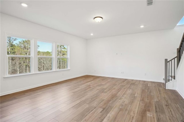 unfurnished room with recessed lighting, visible vents, light wood finished floors, and stairs