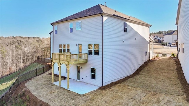 rear view of house with a patio area and fence