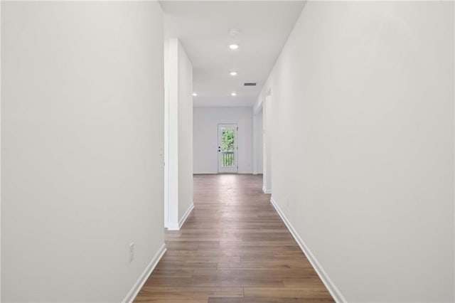 hall with recessed lighting, wood finished floors, visible vents, and baseboards