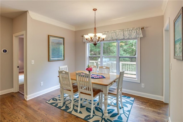 dining area featuring dark hardwood / wood-style floors, ornamental molding, and an inviting chandelier