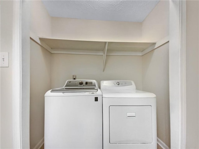 laundry area featuring separate washer and dryer and a textured ceiling