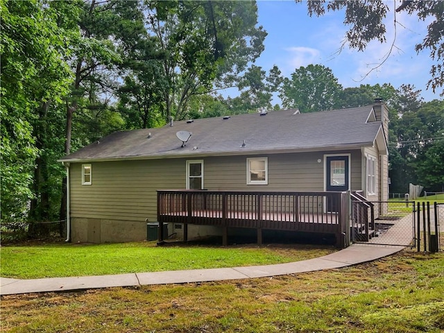 rear view of property featuring a lawn, central AC unit, and a deck