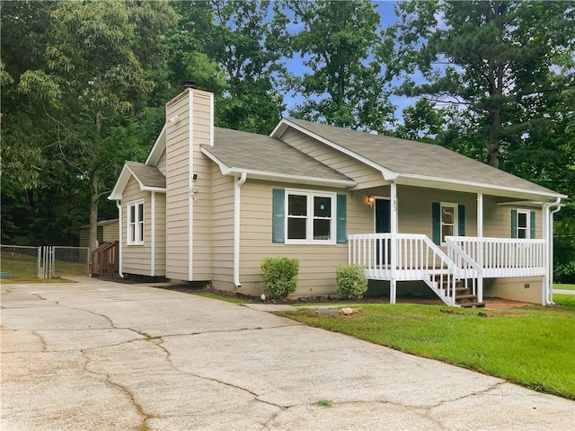 single story home featuring covered porch and a front lawn