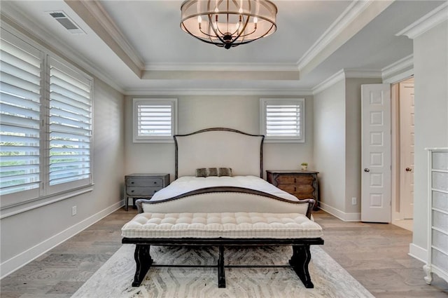 bedroom with an inviting chandelier, multiple windows, a tray ceiling, and visible vents