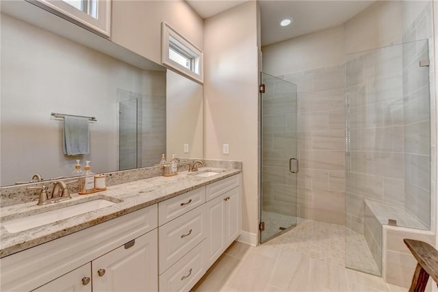 bathroom featuring a sink, tile patterned floors, a shower stall, and double vanity