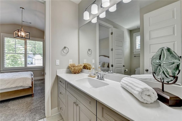 bathroom with vanity, lofted ceiling, toilet, baseboards, and ensuite bath
