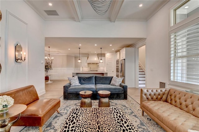 living area featuring a healthy amount of sunlight, stairs, a chandelier, and visible vents
