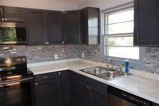 kitchen featuring a wealth of natural light, backsplash, stainless steel appliances, and sink