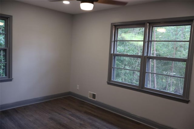 spare room with dark wood-type flooring and ceiling fan