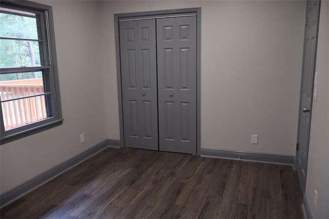 unfurnished bedroom featuring a closet and dark hardwood / wood-style floors