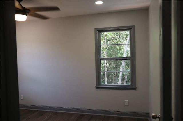 unfurnished room with dark wood-type flooring, a wealth of natural light, and ceiling fan