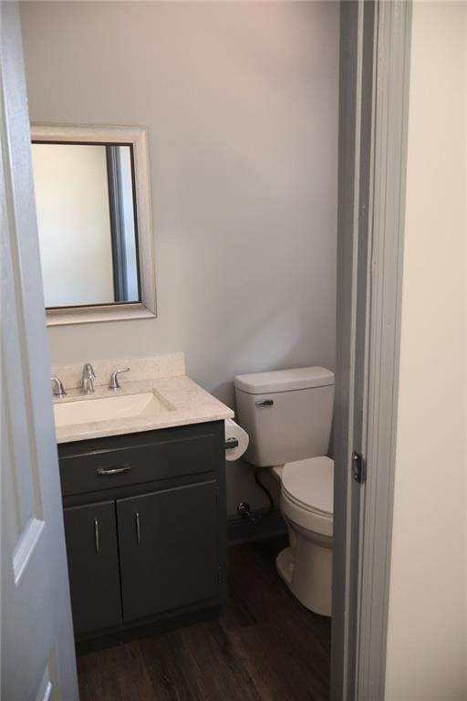 bathroom featuring toilet, hardwood / wood-style flooring, and vanity