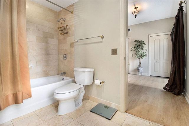 bathroom with toilet, baseboards, washtub / shower combination, and tile patterned flooring