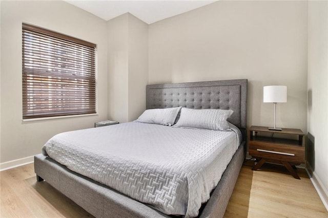 bedroom featuring baseboards and wood finished floors