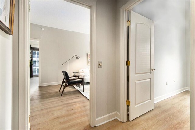 hallway with baseboards and light wood-type flooring