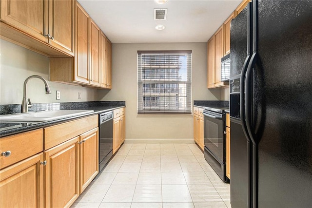 kitchen featuring visible vents, dark countertops, baseboards, a sink, and black appliances
