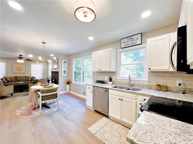 kitchen featuring decorative backsplash, white cabinets, sink, decorative light fixtures, and stainless steel appliances