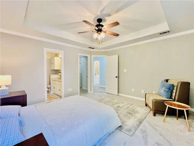 bedroom featuring a spacious closet, a tray ceiling, a closet, ceiling fan, and light colored carpet