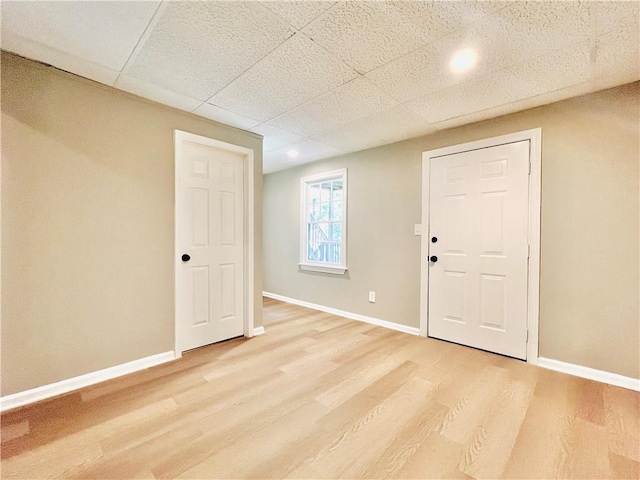 spare room with a drop ceiling and wood-type flooring