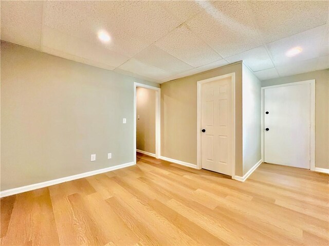 interior space featuring a paneled ceiling and hardwood / wood-style floors