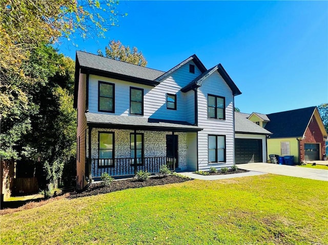 view of front of house featuring covered porch, a garage, and a front lawn