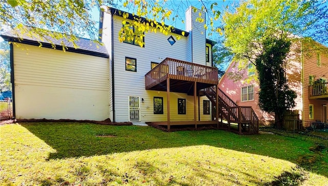 back of property featuring a wooden deck and a lawn