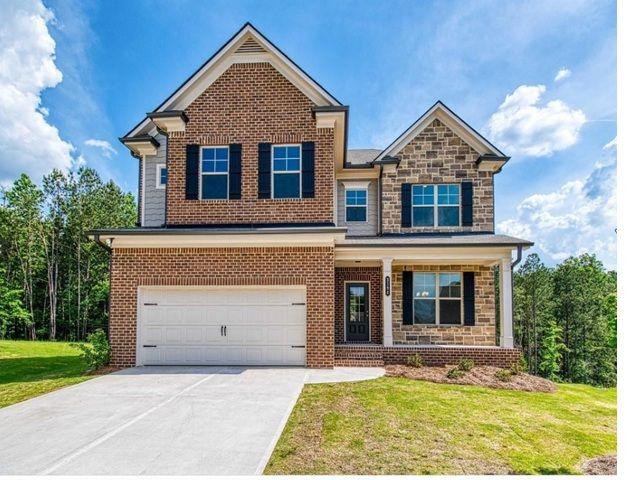 view of front of property with brick siding, an attached garage, a front yard, stone siding, and driveway