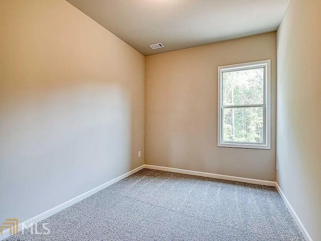 empty room featuring baseboards, visible vents, and carpet flooring