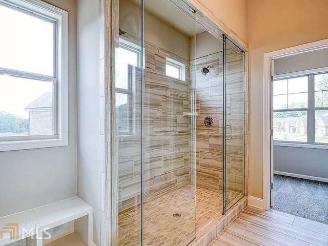 bathroom with a stall shower and baseboards