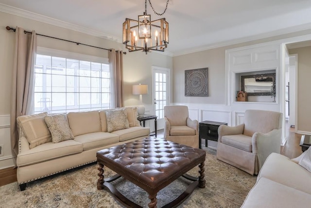 living area with an inviting chandelier, wood finished floors, crown molding, and a decorative wall