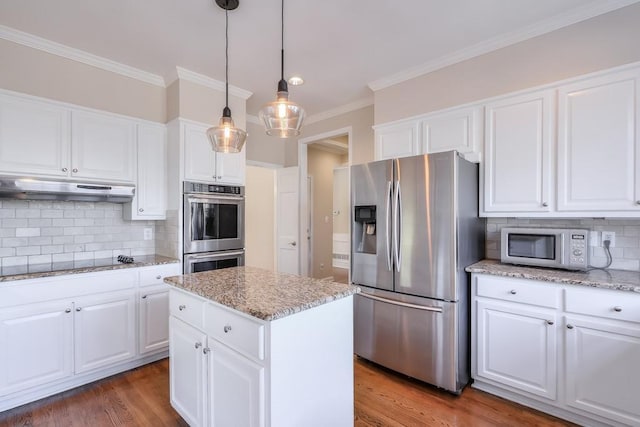 kitchen with ornamental molding, under cabinet range hood, wood finished floors, white cabinetry, and appliances with stainless steel finishes