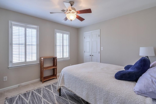 carpeted bedroom with a ceiling fan, baseboards, and a closet