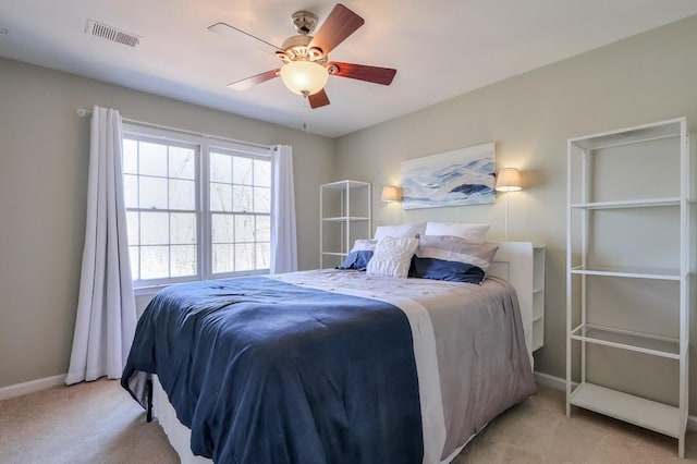 bedroom featuring visible vents, baseboards, light colored carpet, and a ceiling fan