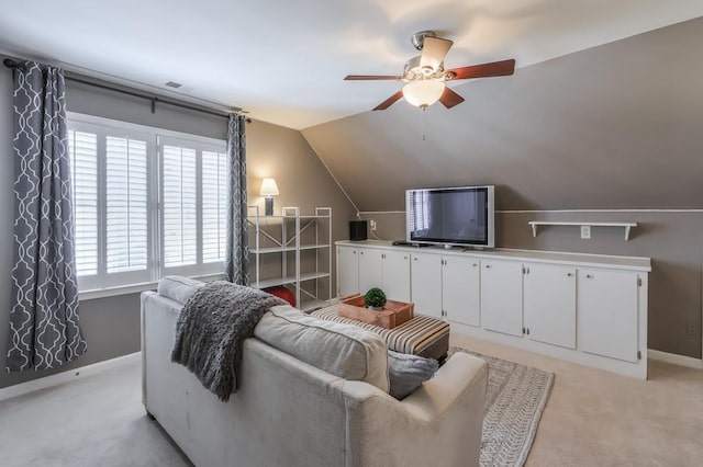 living room featuring baseboards, lofted ceiling, light carpet, and a ceiling fan