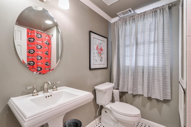 bathroom featuring baseboards, visible vents, a sink, ornamental molding, and toilet