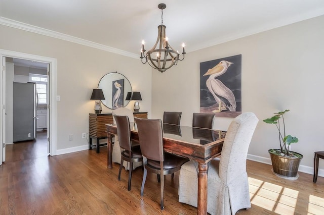 dining room with a notable chandelier, wood finished floors, and baseboards