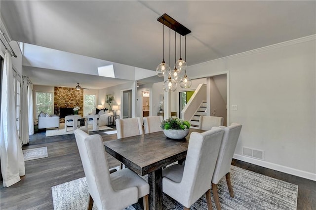 945 Tiber Cir, Alpharetta, GA 30022 - dining space featuring stairway, dark wood-style flooring, baseboards, a fireplace, and a chandelier