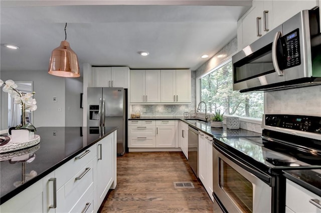 945 Tiber Cir, Alpharetta, GA 30022 - kitchen with appliances with stainless steel finishes, a sink, dark wood-type flooring, white cabinets, and tasteful backsplash