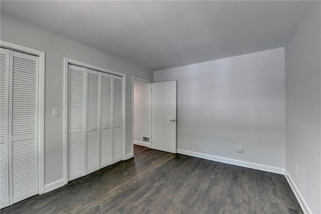 945 Tiber Cir, Alpharetta, GA 30022 - unfurnished bedroom with baseboards, wood finished floors, and two closets