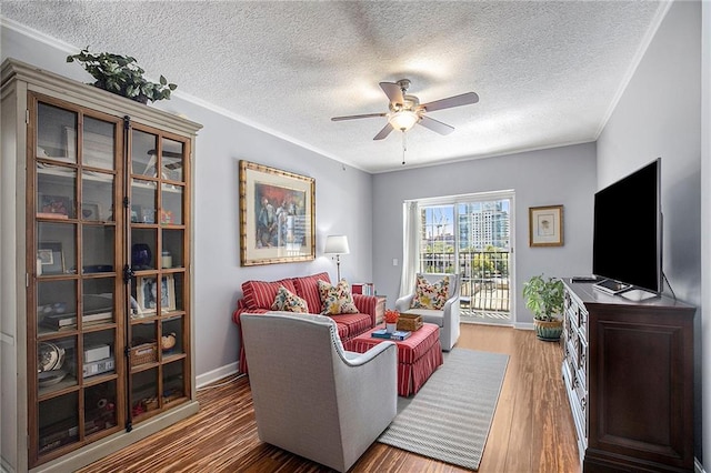 living room with a textured ceiling, ceiling fan, ornamental molding, and hardwood / wood-style flooring