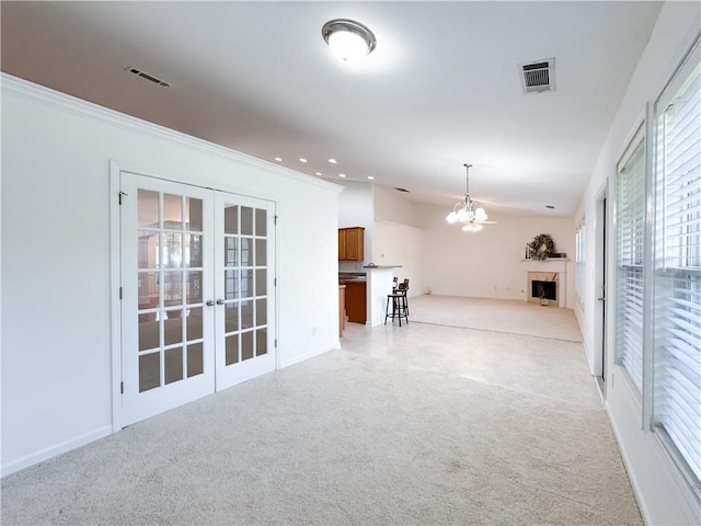 2642 Colleen Ln, Dacula, GA 30019 - unfurnished living room with light carpet, french doors, a chandelier, a fireplace, and crown molding