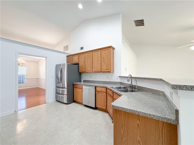 2642 Colleen Ln, Dacula, GA 30019 - kitchen featuring appliances with stainless steel finishes, a sink, a peninsula, a chandelier, and brown cabinets