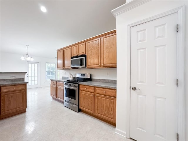 2642 Colleen Ln, Dacula, GA 30019 - kitchen with stainless steel appliances, a chandelier, brown cabinets, and dark countertops