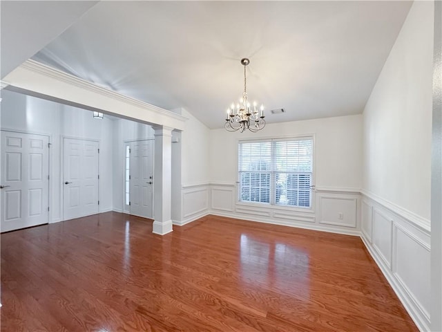 2642 Colleen Ln, Dacula, GA 30019 - unfurnished dining area featuring a chandelier, wood finished floors, wainscoting, ornate columns, and lofted ceiling