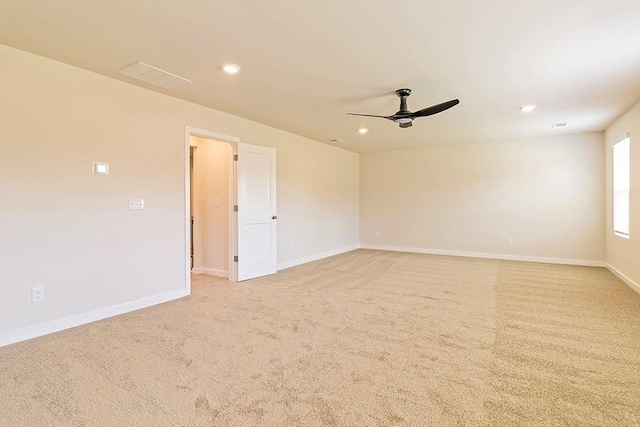 empty room featuring recessed lighting, light colored carpet, visible vents, a ceiling fan, and baseboards